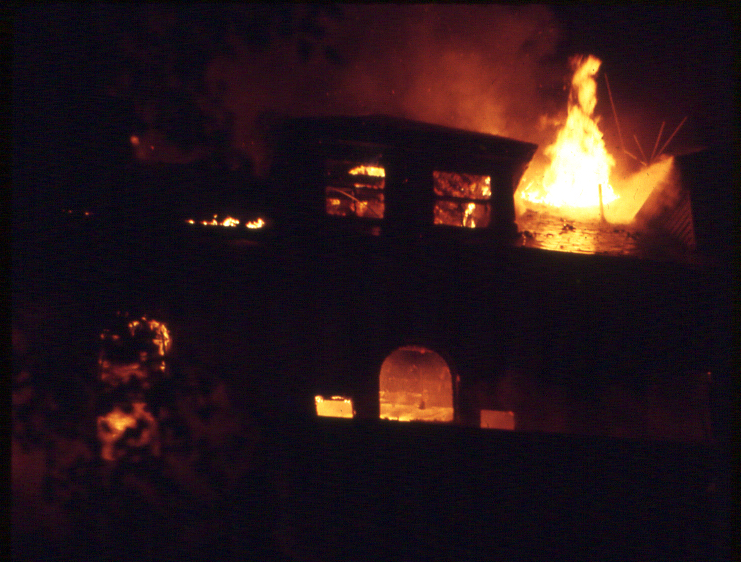 The second and third floor of the mansion is silhouetted by flames on Aug. 30, 1972. Photo by Nick Devlin.