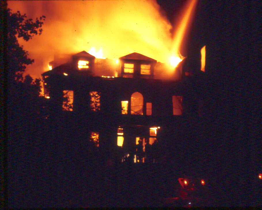 Firefighters can be seen entering the front door of Breeze Knoll as the mansion burned on Aug. 30, 1972. Photo by Nick Devlin.